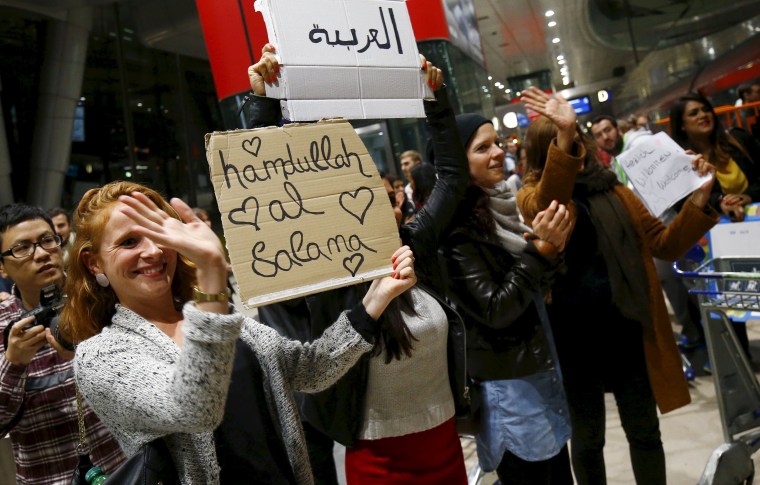 Image: Wellwishers applaud and hold up signs welcoming migrants as Syrian families disembark a train that departed from Budapest's Keleti station at the railway station of the airport in Frankfurt
