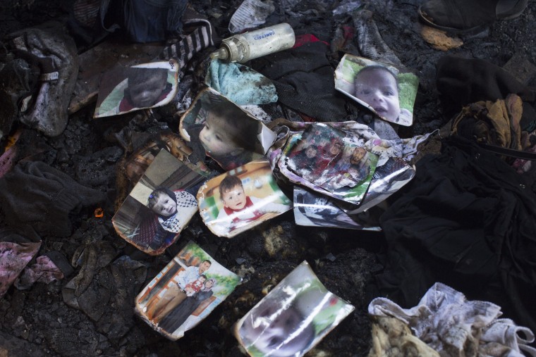 Image: Pictures sit on the floor of a West Bank home that was destroyed by a fire suspected to have been set by Jewish extremists