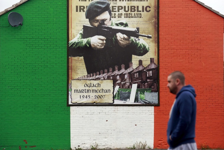 Image: A man walks past a mural supporting the Irish Republican Army