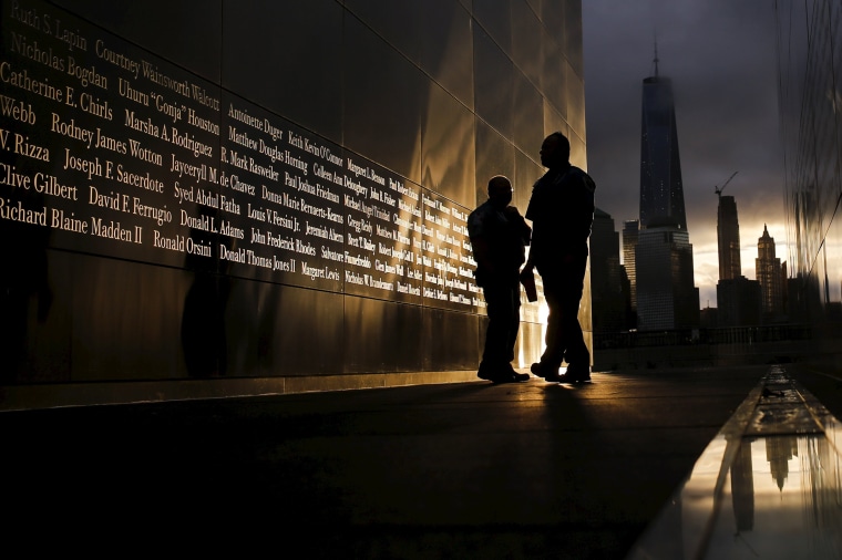 Image: People read the victims' names of the 9/11 Empty Sky memorial