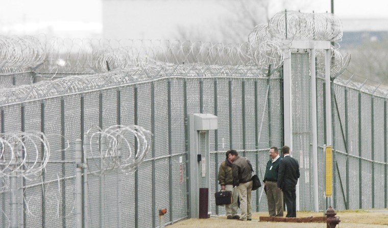 Men wait outside the Cimarron Correctional Facility, in Cushing, Oklahoma, were a prison riot occurred Tuesday, March 22, 2005, leaving one inmate dead, another inmate is listed in critical condition, plus others also injured. (