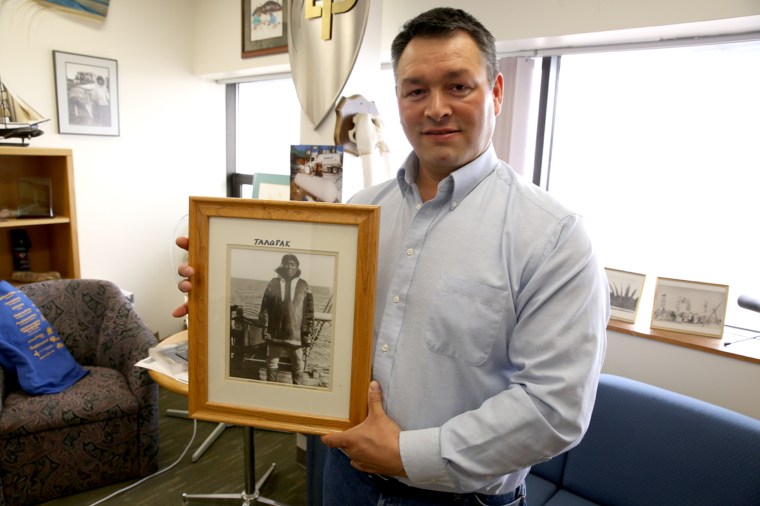 Crawford Patkotak holds a photo of his great-grandfather. He and his kids are navigating a changing way of life in Barrow, Alaska.