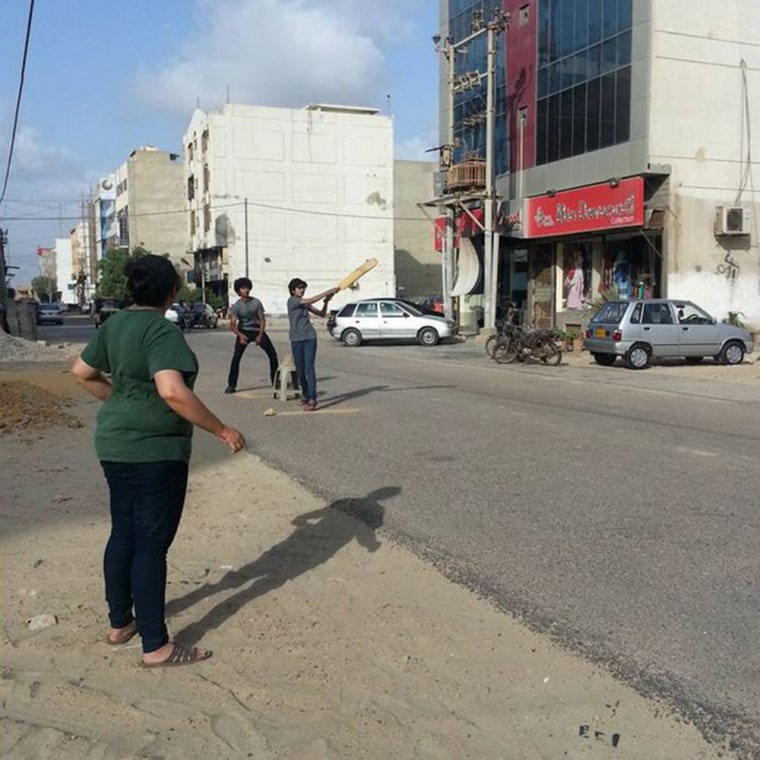 Young women play cricket on a street in Karachi, Pakistan.