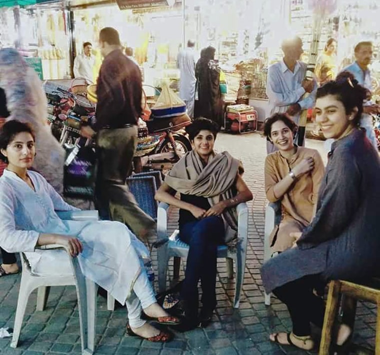 Image: Four young women who are part of the #GirlsAtDhabas sit at a market in Lahore, Pakistan