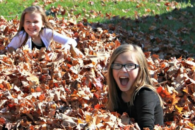 Girls playing in fall leaves
