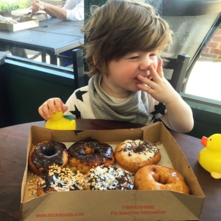 Toddler laughing with donuts