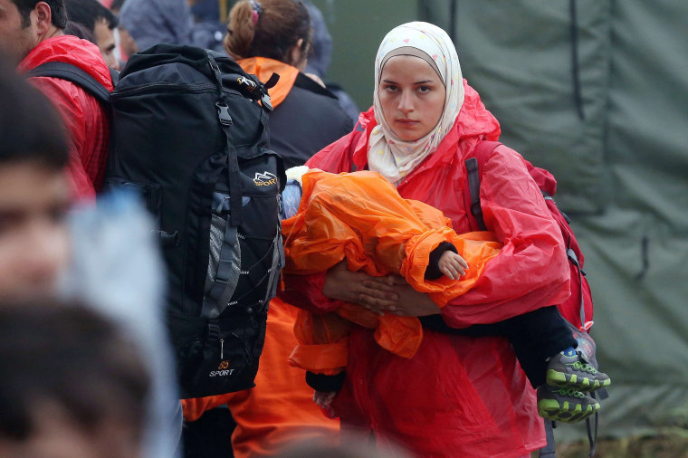 Image: A migrant woman carrying her child arrives