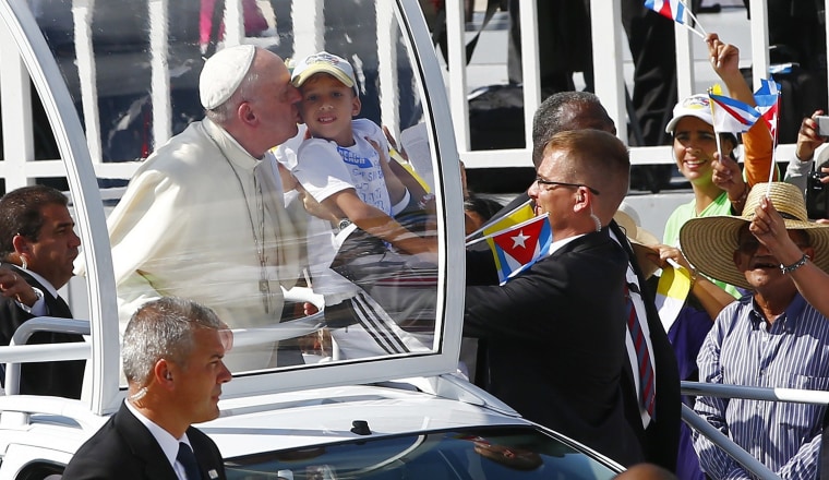 Image: Pope Francis kisses a child as he arrives to lead a mass for Catholic faithful in the city of Holguin