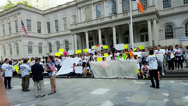 Chinese-American nail salon owners and workers gather on the steps of New York’s City Hall Monday to protest enforcement of the state’s nail salon legislation, signed into law in July.