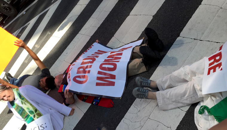 Protesters calling for the ordination of women stage a lie-in across from St. Matthew's just before the pope's scheduled arrival.