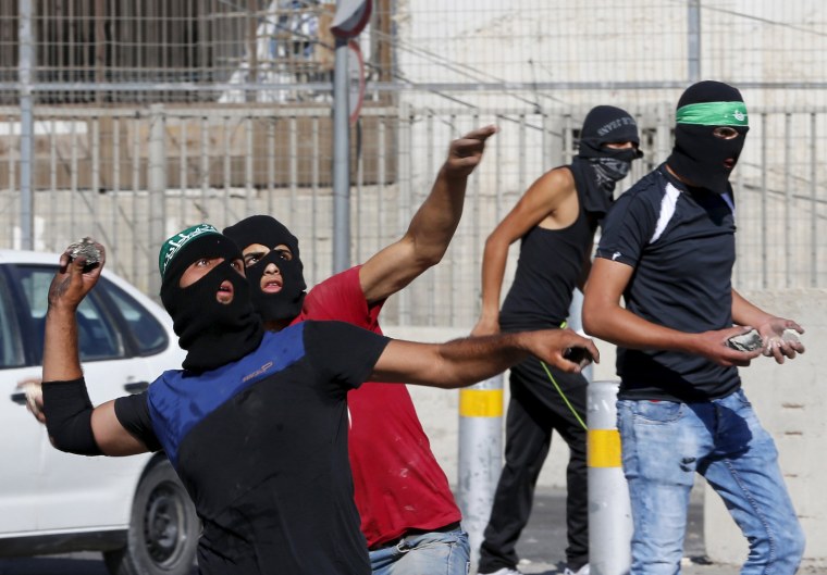 Image: Palestinians hurl stones towards Israeli border police