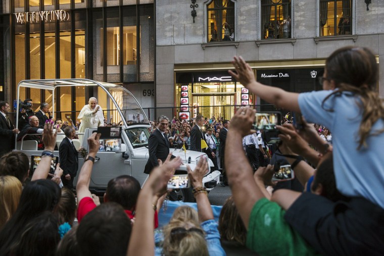 Image: Pope Francis waves from his vehicle as he is driven down 5th avenue