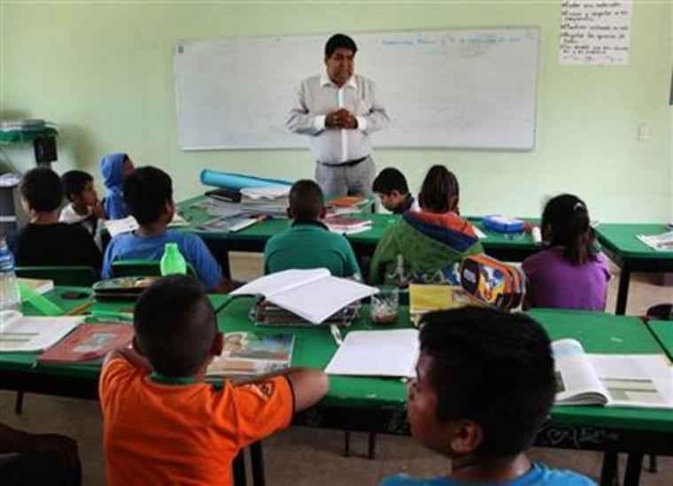 In this Sept. 15, 2015 photo, Cuitlahuac Mondragon, the uncle of slain college student Julio Cesar Mondragon, teaches at an elementary school in San Miguel Tecomatlan, a rural town in the hills of Mexico state. Julio was slain on Sept. 26, 2014 in Iguala during an attack in which 43 students disappeared. Julio liked to challenge the teachers, Cuitlahuac said. He also taught reading and writing to poor families in San Miguel Tecomatlan, a rural town in the hills of Mexico state.