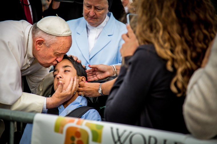 Pope Francis kisses Michael Keating, a 10-year-old boy who suffers from cerebral palsy, after arriving in Philadelphia.