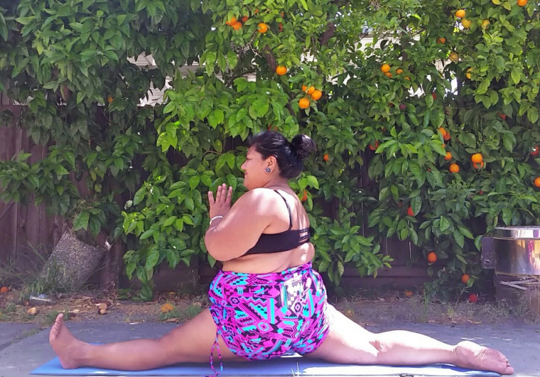 Valerie Sagun, known online as "Big Gal Yoga," demonstrates a split.