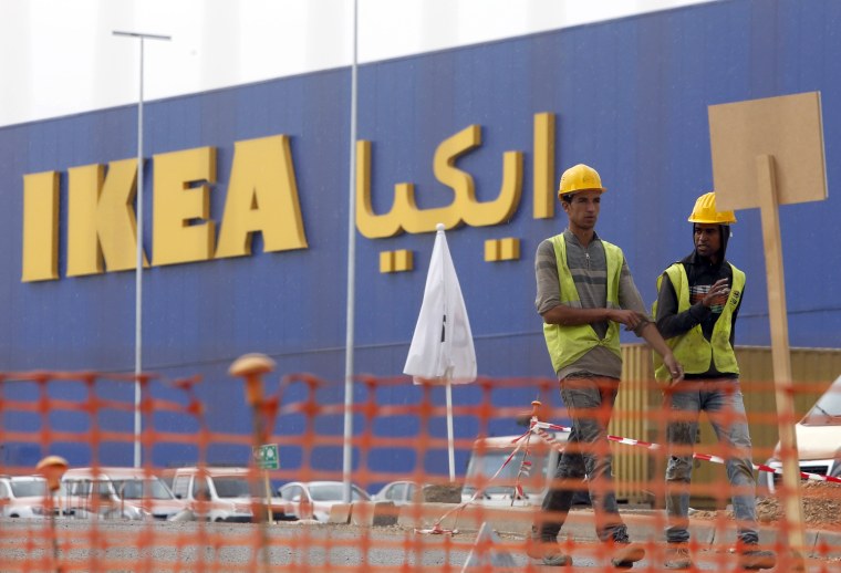 Image: Moroccan workers walk past the construction site of the country's first Ikea store near Casablanca, Morocco,