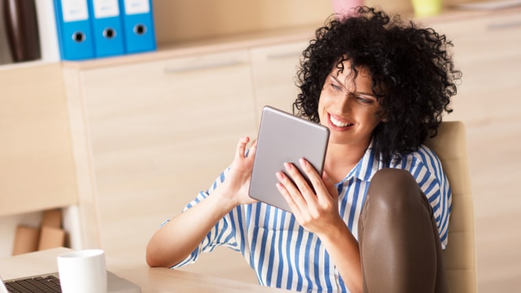 Woman using tablet, she sitting at the desk in her office;