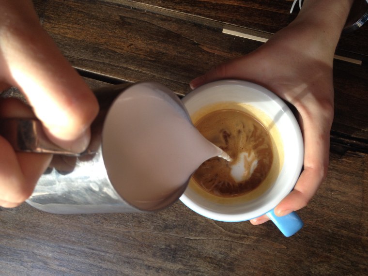 Pour a dollop of steamed milk into espresso