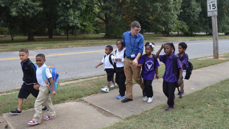 Teacher walks children home.