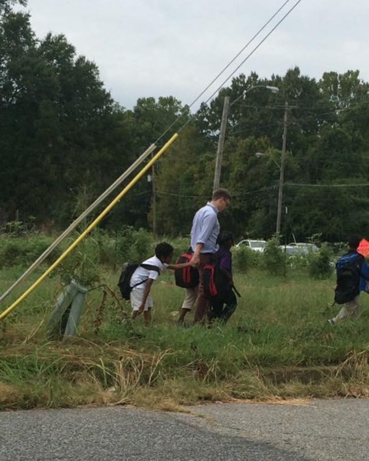 Teacher walks children home.