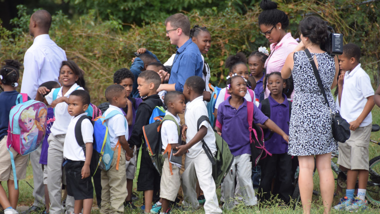 Teacher walks children home.