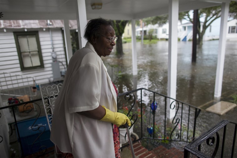 Image: McKnight watches the level of floodwaters in the front yard of her Orange Street home in Georgetown, South Carolina