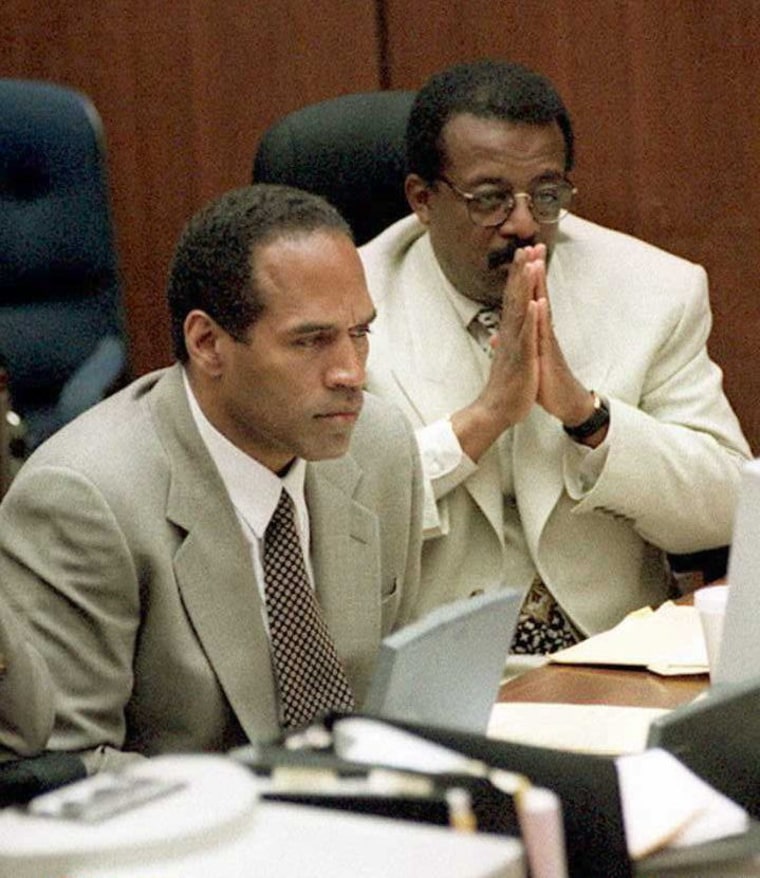 Murder defendant O.J. Simpson (L) watches a monitor