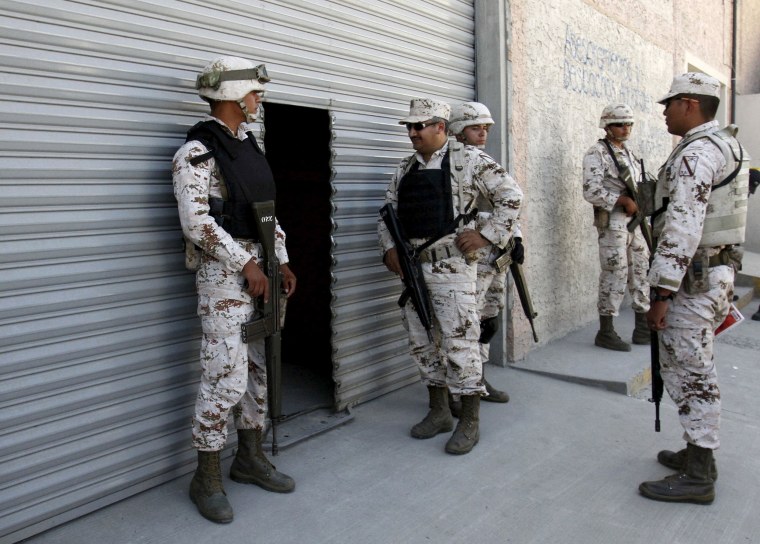 Image: Soldiers of the Mexican Army stand guard outside a warehouse containing a tunnel discovered by Mexican Army, in Tijuana