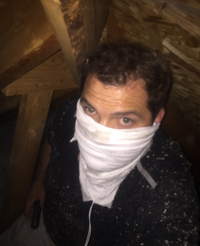 Who is that masked man? It's the Singing Contractors' Josh Arnett, who protects himself while doing mold remediation treatment in an attic.