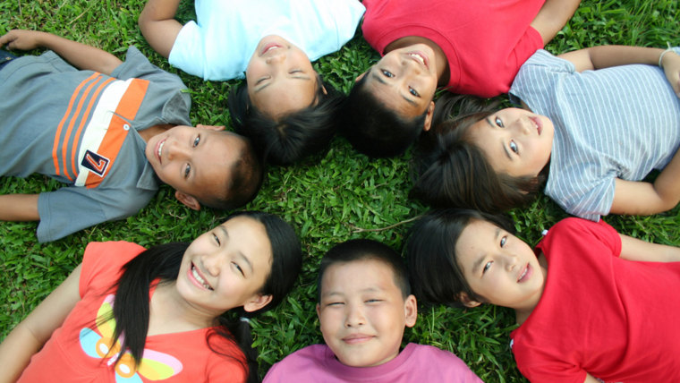 Seven children playing in the park.