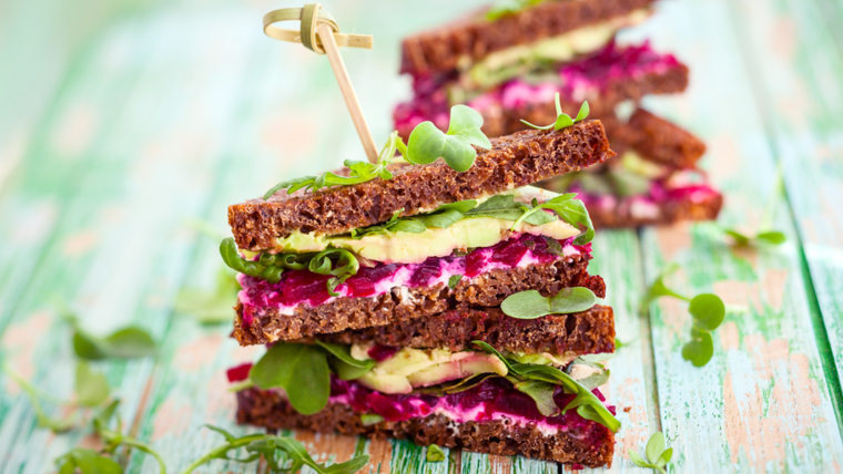 Sandwich with beet, cheese, avocado and arugula