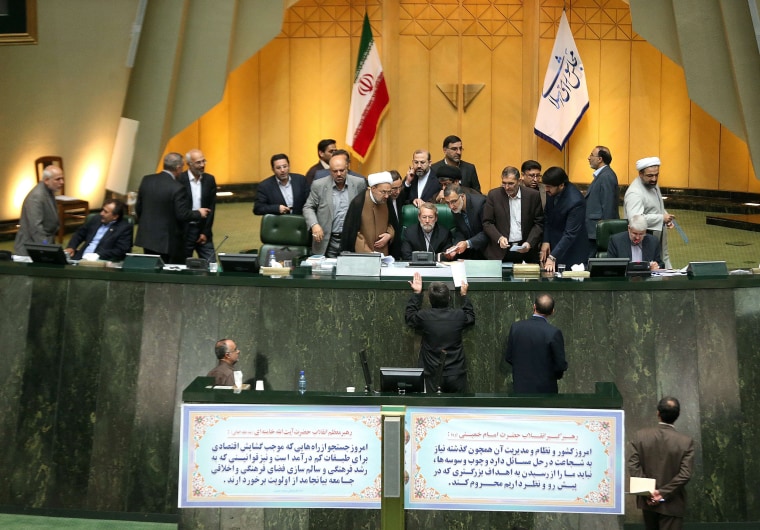 Image: Iran's Parliament Speaker Ali Larijani (C) listens to a deputy