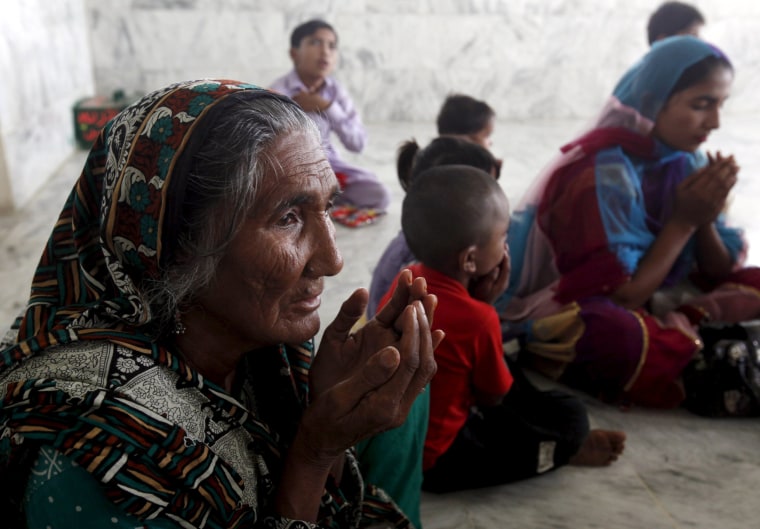 Image: Women and children pray at the shrine