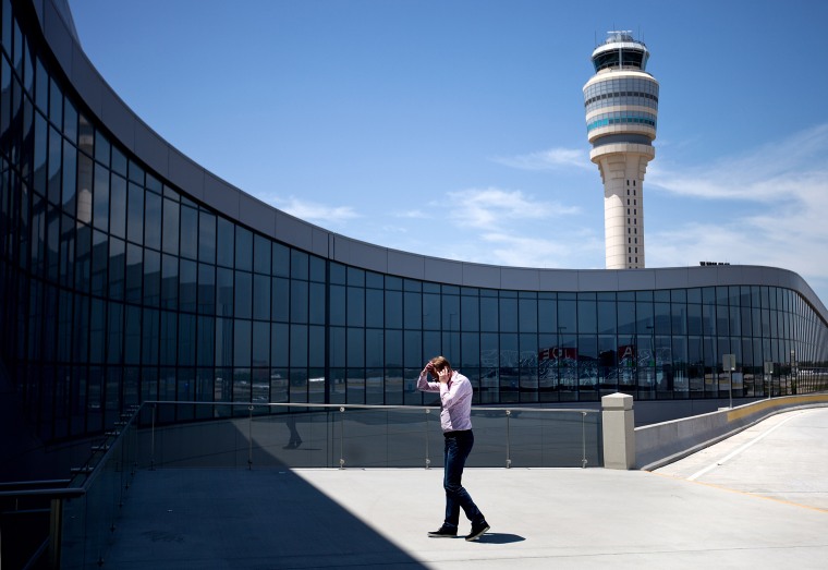 Image: A passenger walks while on the phone outside the international terminal at Hartsfield-Jackson airport