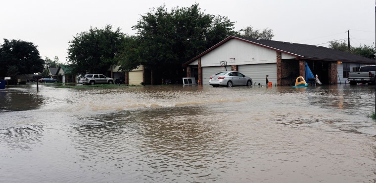 Image: Water flows into a neighborhood in Midland County