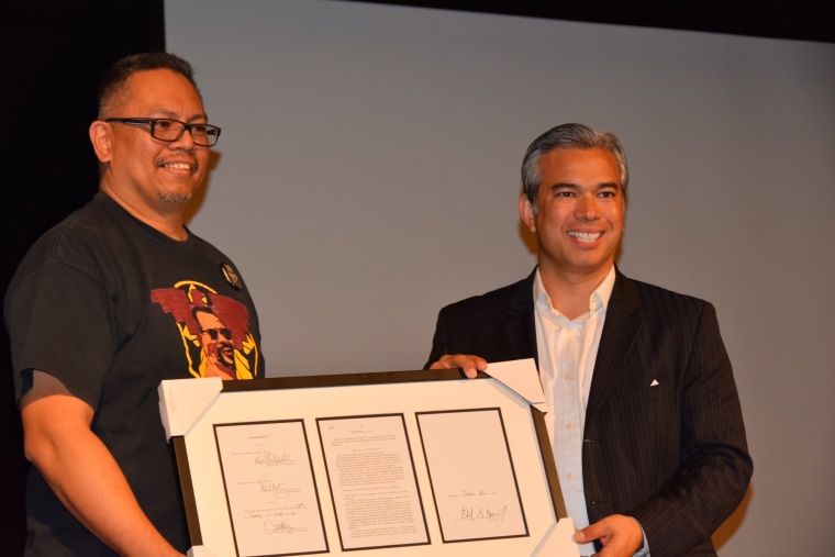 Johnny Itliong receives a copy of the bill that made Oct. 25 Larry Itliong Day annually in California from Assemblyman Rob Bonta.