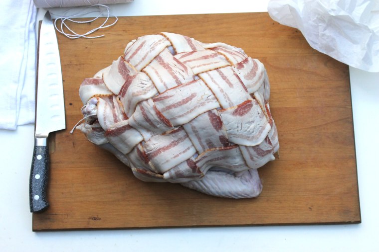 How to make bacon-wrapped turkey: arrange the bacon square so that the 4 corners are at the neck, the cavity and both wings. 