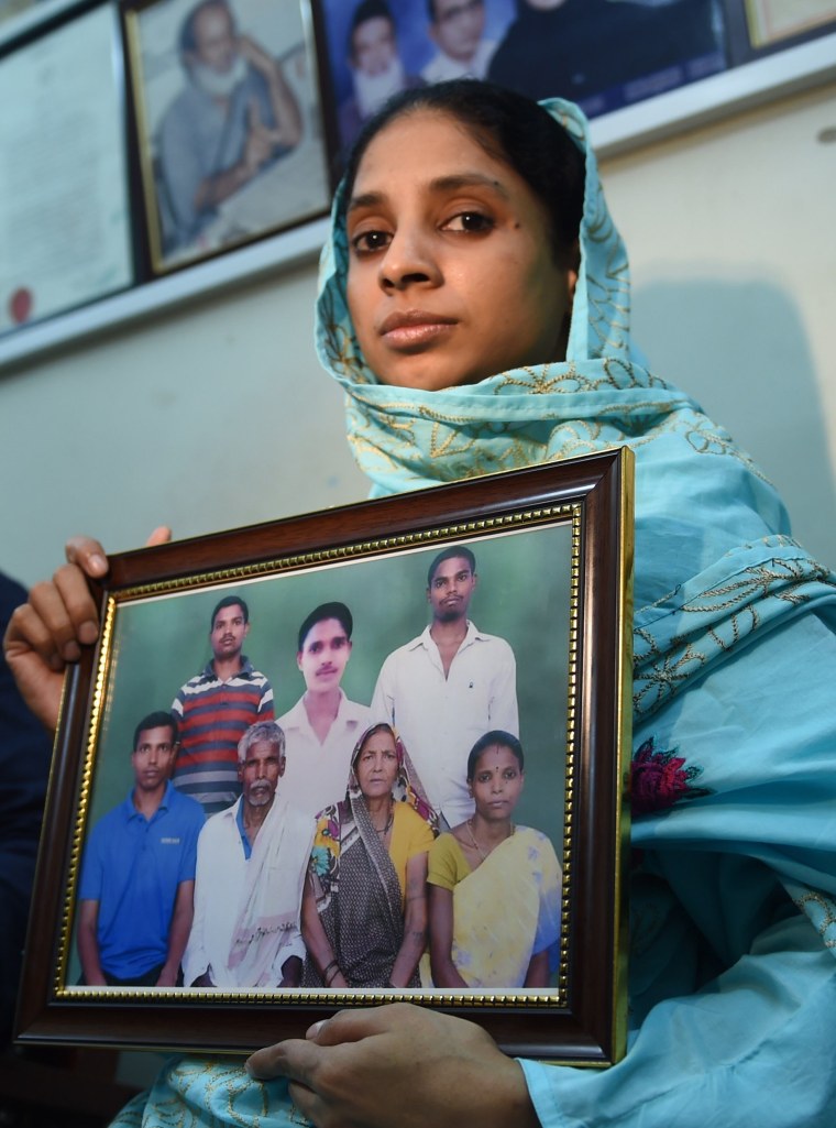 Image: Geeta holds a photograph possibly of her family on Oct. 15