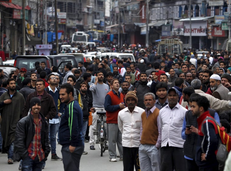 Image: People stand on a road after vacating buildings
