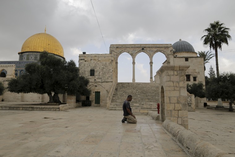 Image: A Muslim man prays near the Dome of the Rock  in Jerusalem