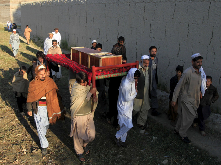 Image: Afghan men carry a coffin of an earthquake victim for burial in Nangarhar province, Afghanistan