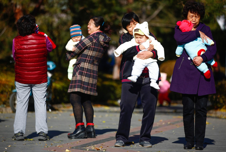 Image: Parents and babies gather at a park in Beijing