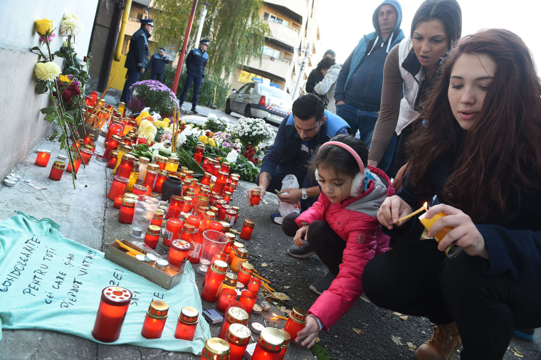 Image: People light candles at a memorial outside the nightclub