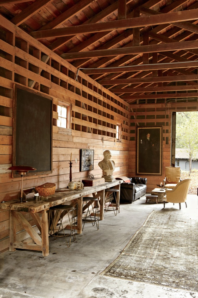 In the Romantic Barn, which we used as a game room, a midcentury American industrial worktable with stone bust of a man (French, 1900s) sets the mood. The leather chesterfield (American 1940s) and a pair of deconstructed nineteenth-century French chairs surround a French turn-of-the-century artist’s stand we used as a coffee table. A nineteenth-century portrait of a gentleman and a Prouvé jib lamp above the sofa created a nice lounge area for us.