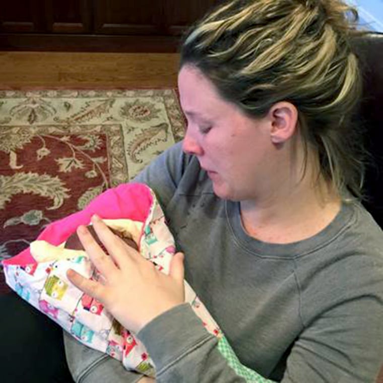 Jami holds Ella and Stella, her twin daughters who died from Twin to Twin Transfusion Syndrome, in the funeral home.