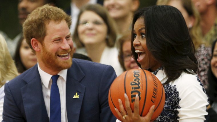 Image: Britain's Prince Harry hands U.S. first lady Michelle Obama the basketball at the end of a game played by wounded warriors at Fort Belvoir, Virginia