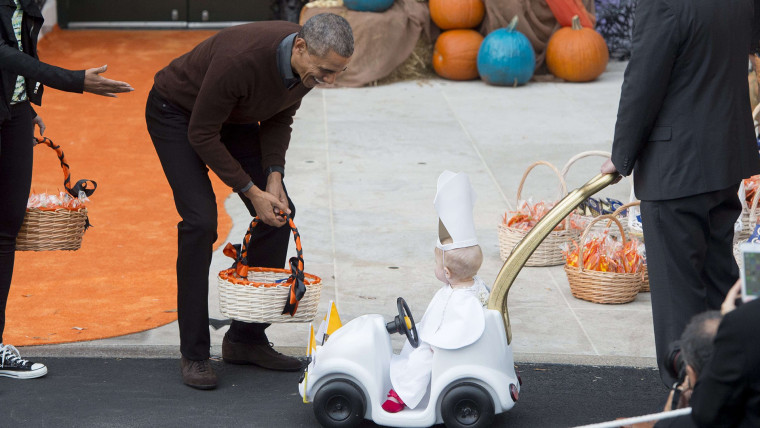 Obama greets a young child dressed as the Pope