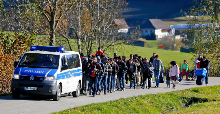 Image: Migrants are escorted by German police to a registration center