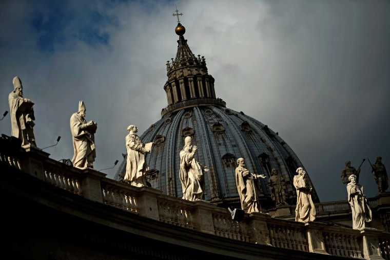 Image: Statues and the dome of St. Peter's basilica at the Vatican in Rome