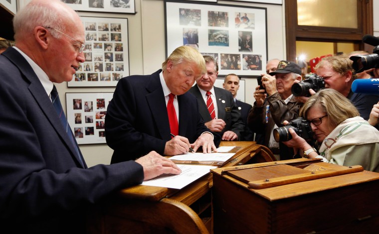 Image: Donald Trump fills out his papers to be on the nation's earliest presidential primary ballot